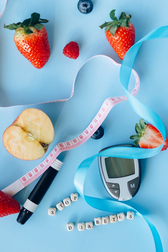 Fruits, glucose meter, and ribbon on a blue background symbolize diabetes awareness and healthy living.